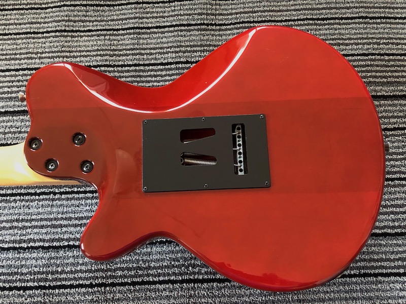 The body shows its three-piece construction with deep belly cut and a neck attatched with very stable machine bolts and bushings. 